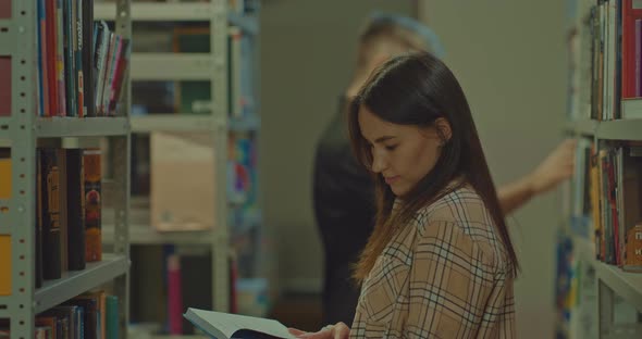 Nice Woman Looks at the Book with Enthusiastically and Flips Through the Pages alt