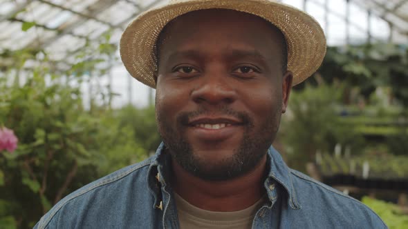 Portrait of Cheerful Afro-American Male Farmer in Greenhouse alt