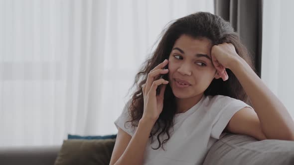 Beautiful Young African American Lady Chatting on Her Mobile Listening to a Call with a Wide Beaming alt