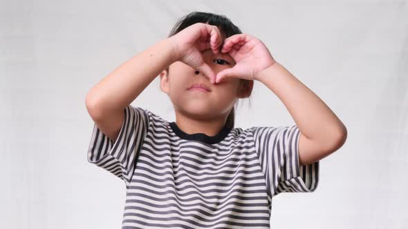 Healthy eyes and vision. Pretty little girl making heart gesture alt