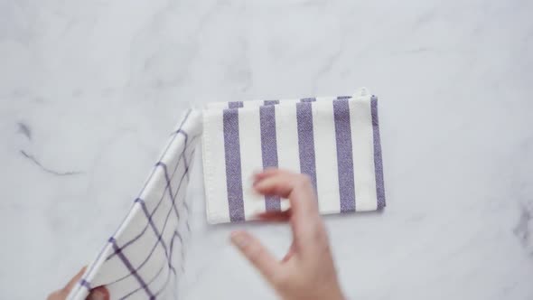 Folding black and white patterned paper towels on marble surface. alt
