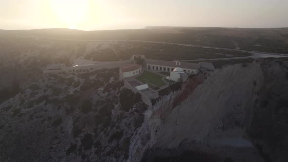 Aerial wide shot of spectacular rock formation in Fortress of Beliche Sagres Algarve Portugal. alt