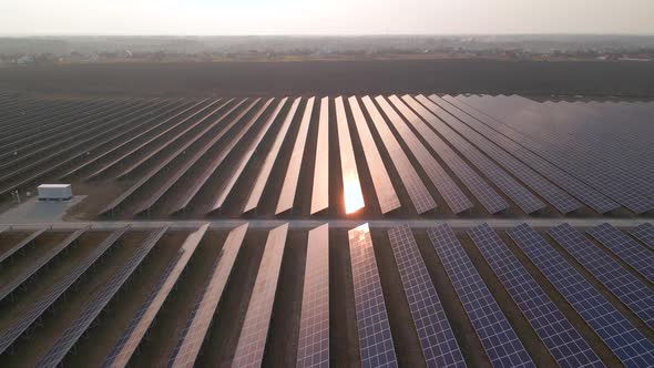 Aerial Drone View Into Large Solar Panels at a Solar Farm at Early Spring Sunset alt