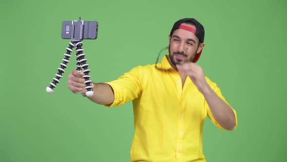 Young Happy Bearded Indian Businessman Vlogging with Phone