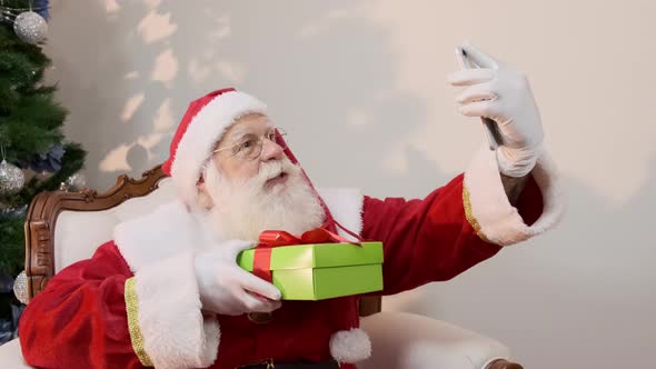 Santa Claus making selfie photos to show that he already has the gift in his hands