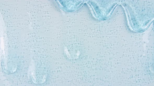 Blue Transparent Cosmetic Gel Fluid With Molecule Bubbles Flowing On The Plain White Surface alt