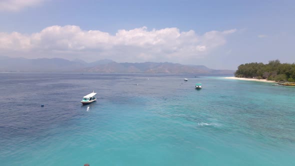 Adisn woman running on wooden jetty of Gili Meno pier during sunshine with epic landscape.Aerial bac alt