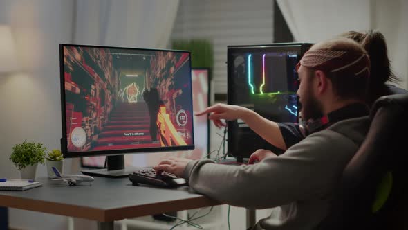 Couple of Gamers Playing First Person Shooter Videogame alt