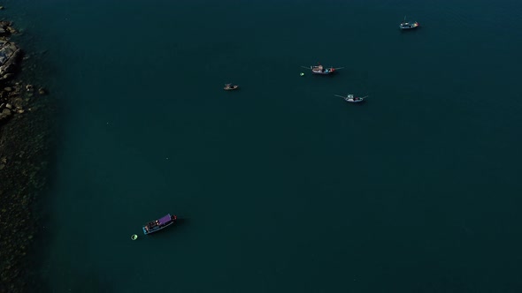Aerial top down shot of fishing boats working on Pacific Ocean during sunny day in Vietnam alt