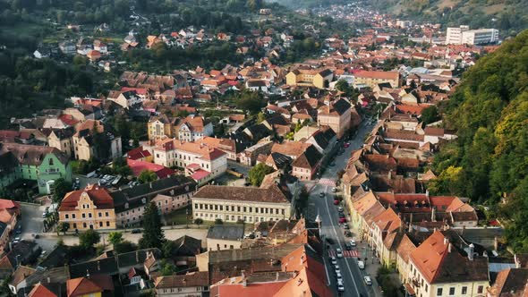 Aerial drone view of Sighisoara, Romania. Roads with cars, greenery and buildings alt