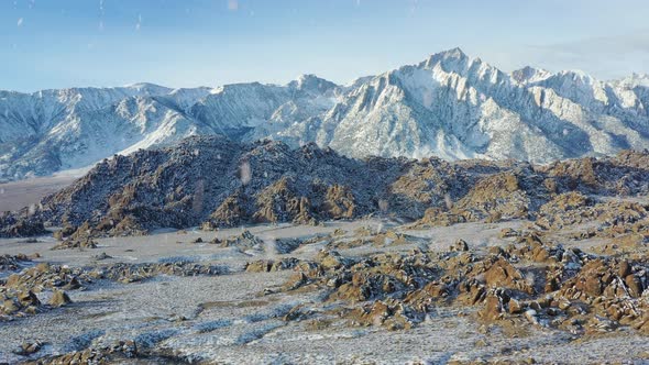 Rocky desert area and mountain range during snowfall, aerial drone view alt