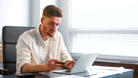 Serious guy company manager with beard pays online alt