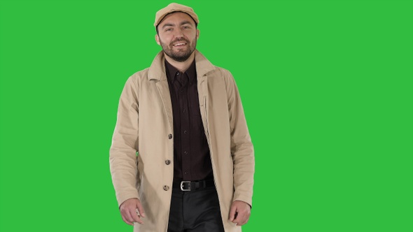 Smiling man in coat is looking at camera and walking on alt