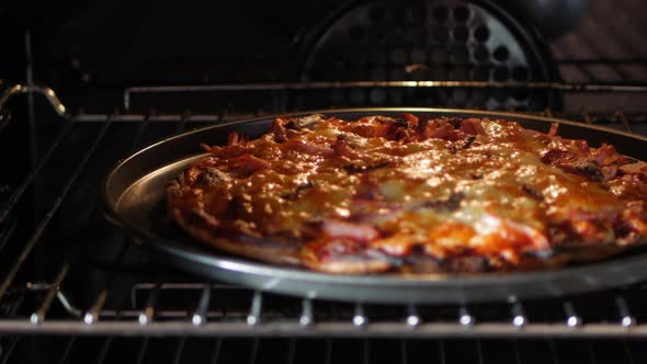 Homemade pizza cooked in an oven. Cheese bubbling, PAN SHOT left to centre. alt