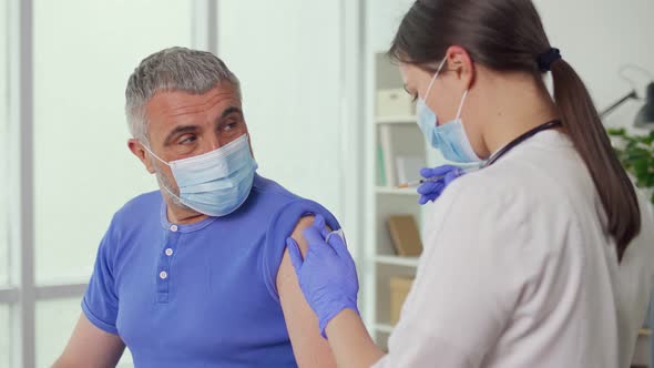 An Older Man Wearing a Protective Mask is Being Vaccinated Against alt
