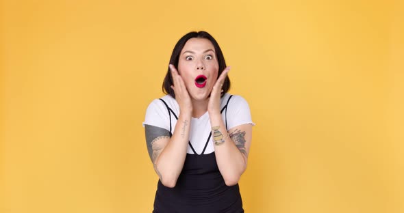 Amazed shocked woman, saying wow standing isolated over yellow background alt