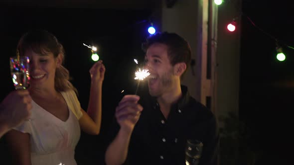 Friends celebrating at night with sparklers and champagne