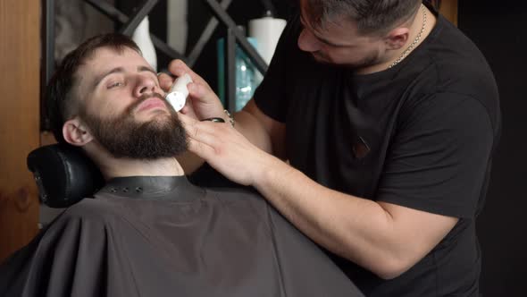 Barber Trimming Beard of Client