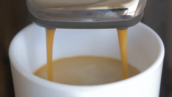 Espresso machine pouring coffe in cup close-up 4K 2160p UHD footage - Espresso machine making hot ba alt