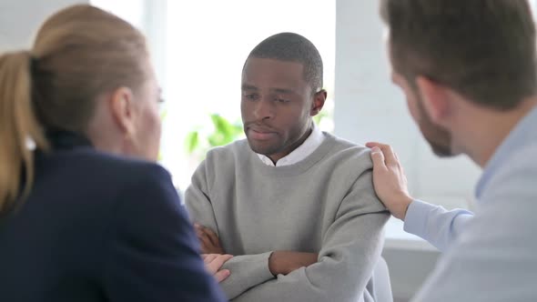Business People Reassuring Upset African Businessman alt