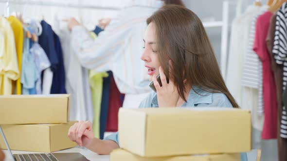 Asian two beautiful woman packing clothes order into box for customer. alt