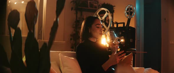 Young woman takes a sip of wine sitting alt