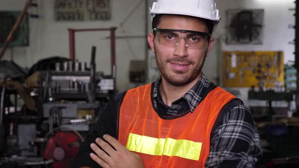 Caucasian male worker putting on hard hat and goggles, and smiling alt