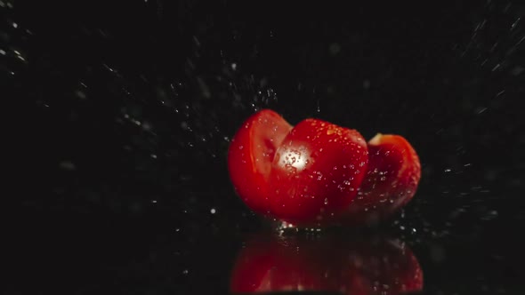 Tomato Falls On A Table And Pieces Scatters In Different Directions