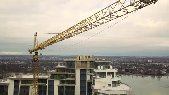 Aerial footage of a tower crane at construction site of new office building alt