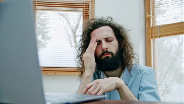 Curly Man of Arab Appearance Rubs His Forehead and Whiskey Because He Has a Headache From a Lot of alt