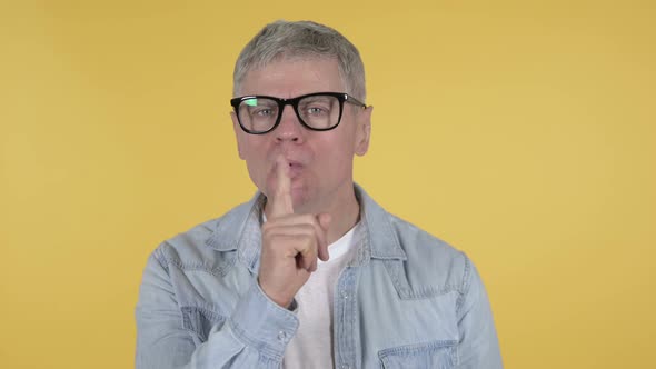 Casual Senior Man Gesturing Silence, Finger on Lips alt