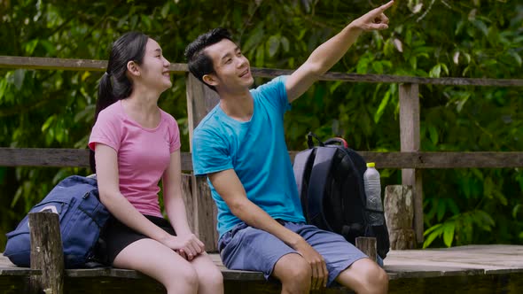 Couple Hikers Sitting And Looking At The View alt