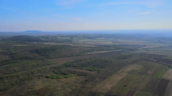 Aerial panorama in springtime field on hillside mountains near village in wonderful landscape alt