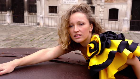 Lady with Flounce on Dress Leans on Old Metal Well Cover alt