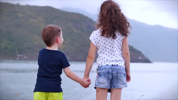 Happy Family Kids Boy And Girl Holding Hands Holding Hands Children Watching The Sea At Sunset Ocean By Gemelstock