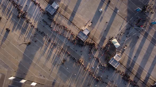 birds eye view slowly turning over people waiting in a long  line to go in to a show in buenos aires alt