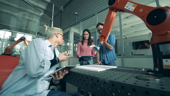 Team of Engineers are Talking About a Drawing Robotic Device alt