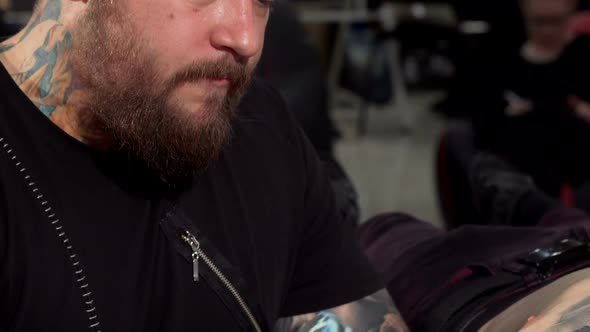 Sliding Shot of a Professional Tattoo Artist Working at His Tattoo Shop alt