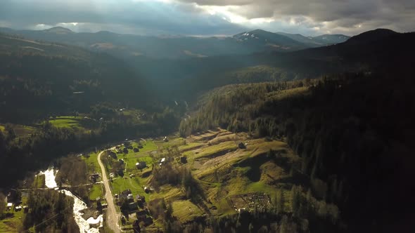 Aerial View of Storm Clouds and a Village in the Mountains alt