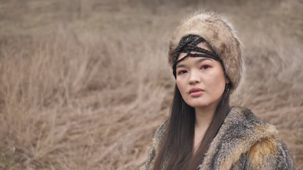 asian young woman in ethnic clothes close-up in the steppe in nature. Slow motion alt