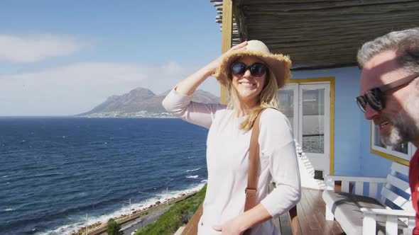 Happy cacusia mature couple coming with suitcases to hotel room alt