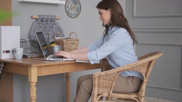 Young Woman Is Typing on Laptop Keyboard alt