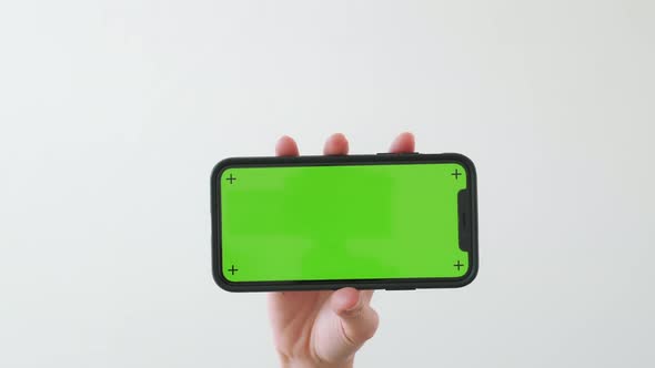 Hand holding smartphone with chroma key screen and showing on the white background alt