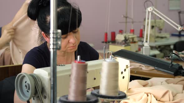 Female Tailor is Working at the Sewing Factory alt