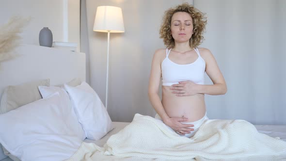 Young Pregnant Woman Practicing Yoga And Breathing Exercise At Home