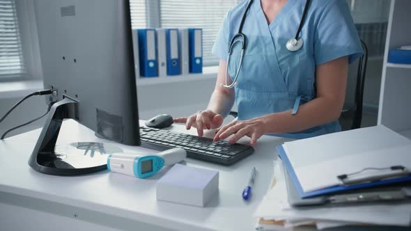 Medical Worker Hands are Typing on Keyboard Closeup Female Doctor is Working at the Computer Sitting
