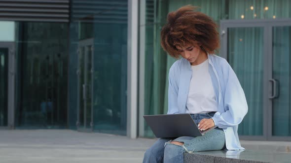 Curly African American Woman Student Girl Female Freelancer User Worker Sitting on Street Outdoors alt
