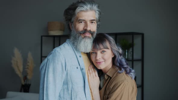 Portrait of Happy Couple Smiling Looking at Camera Standing Indoors at Home alt