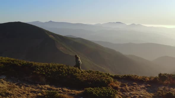 Aerial View of Hiker Man with Backpack on Ridge of a Mountain alt