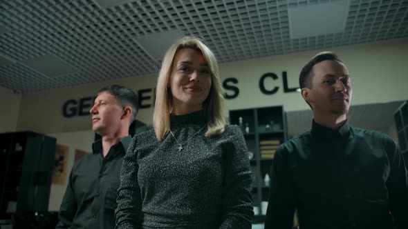 Three Confident Barbers Stand in the Interior of a Barbershop alt